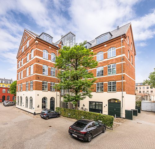 Historisk og velholdt erhvervsejendom på Ryesgade 3F med markant rødstensfacade, store vinduespartier og attraktiv beliggenhed.