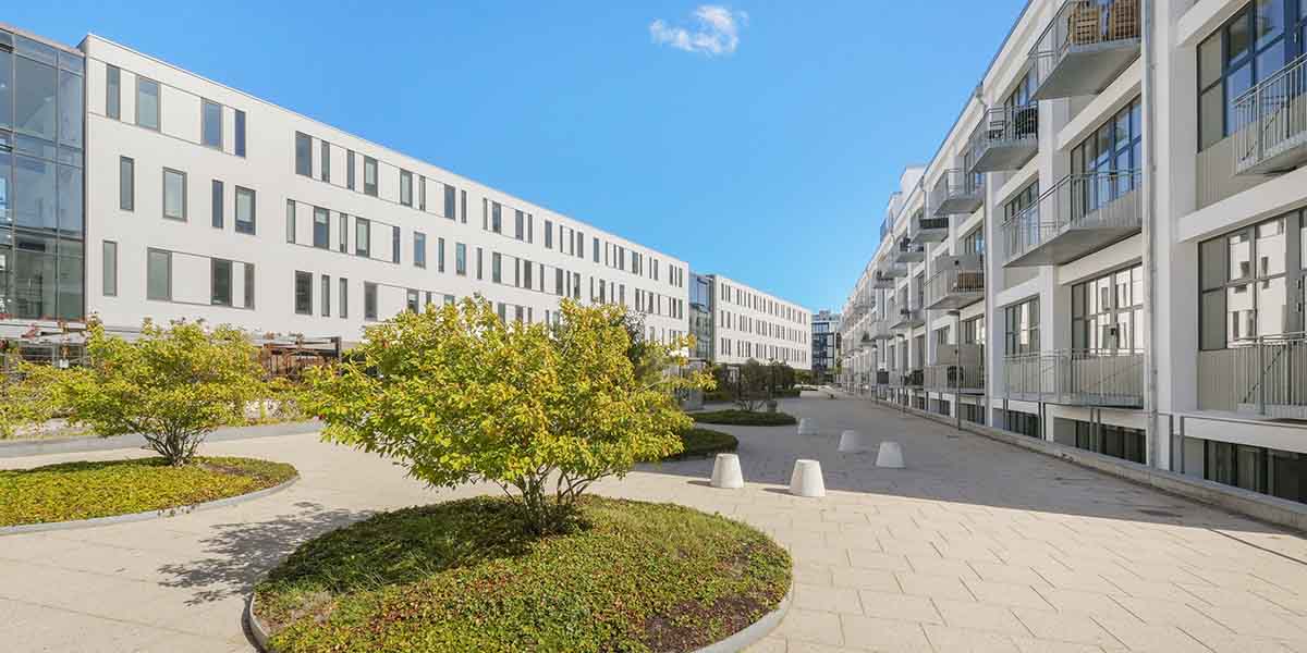 ObelHus facade med blå himmel og grønne bede